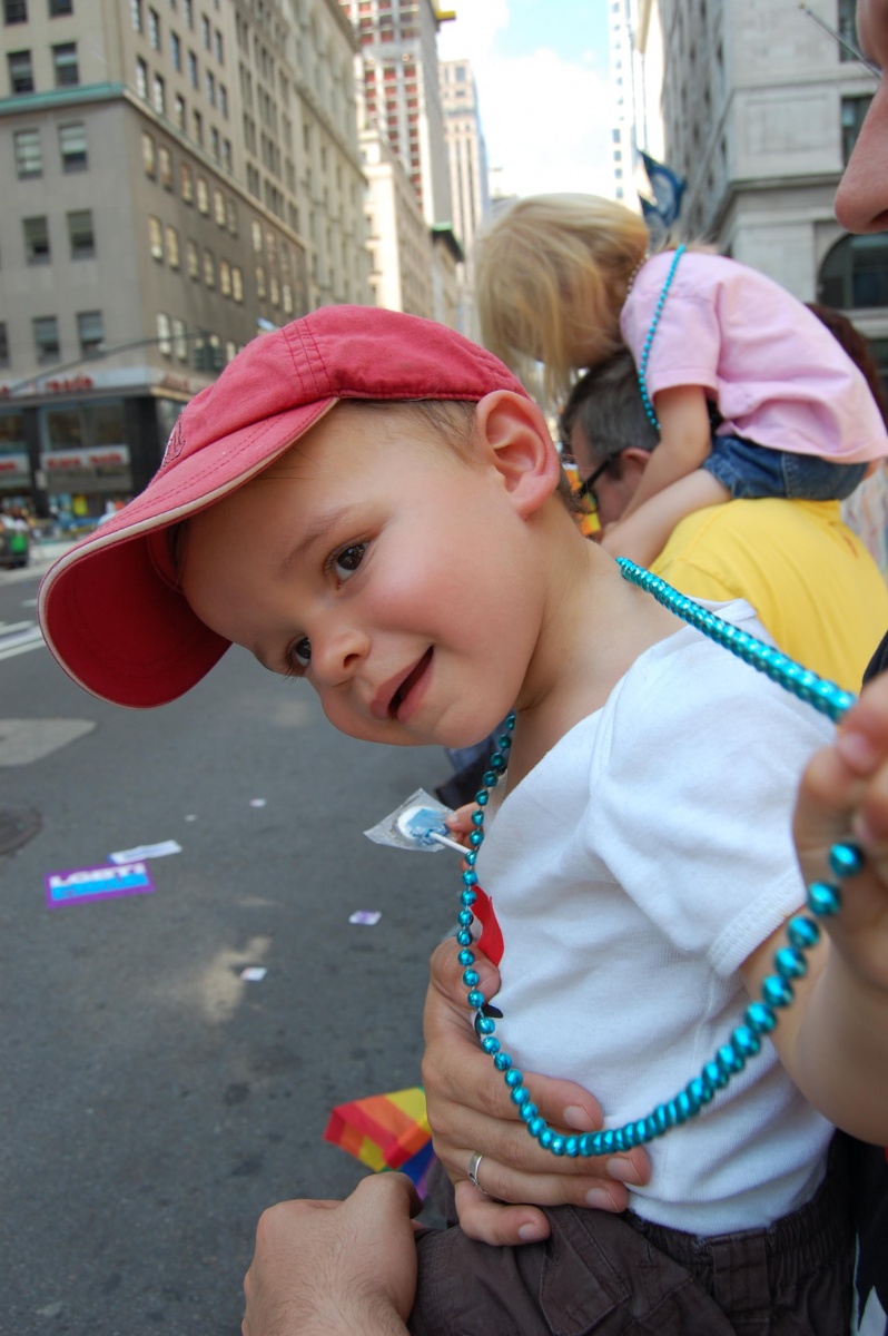 Liam à la gay parade avec son collier bleu qu'il a toujours